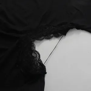 Macro view showing detailed black lace patchwork on a stylish cutout waist dress.