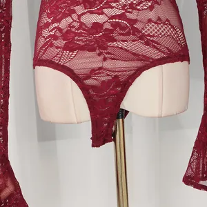 Dettaglio ravvicinato di un body in pizzo bordeaux con maniche svasate su manichino