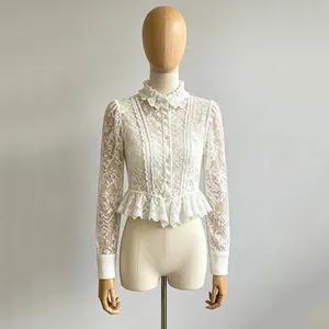 Elegante weiße Langarm-Spitzenbluse mit Rüschenkragen auf einer Schneiderpuppe.