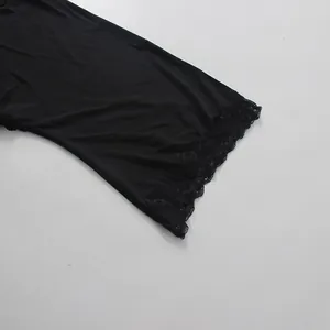 Detailed close-up of elegant black lace trim on the sleeve of a modern mini dress.