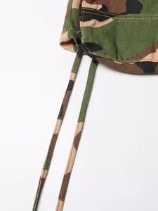 Détail d'une jupe trapèze camouflage montrant la texture du tissu et le cordon réglable.