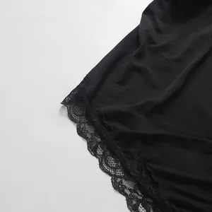 Close-up detail of intricate black floral lace trim on the hem of a stylish dress.