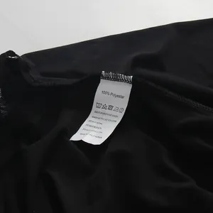 Close-up of 100% polyester washing care label on a black lace patchwork dress