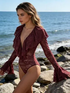Elegante body in pizzo bordeaux con scollo a V profondo e maniche a campana sulla spiaggia