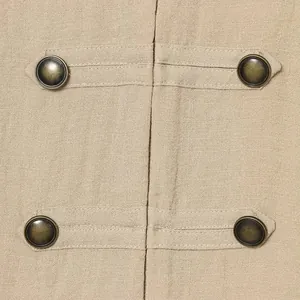 Gros plan des boutons en bronze vintage sur un gilet en lin haut de gamme de couleur kaki