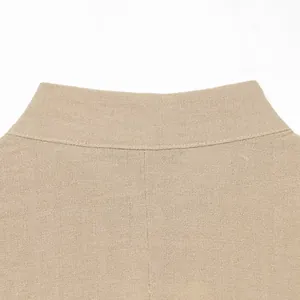 Détail en gros plan d'un gilet en lin beige montrant le col et la texture du tissu.