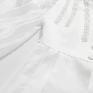 Close-up of elegant white lantern sleeve shirt with delicate pearl beadwork detailing