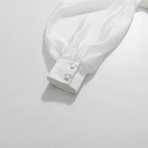 Macro view showing the fine texture and two-button detail of a white satin lantern sleeve.