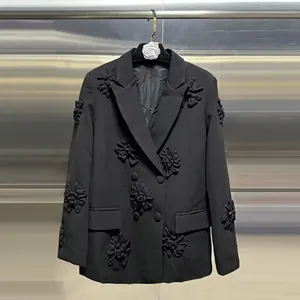 Dettaglio delle intricate applicazioni floreali in tessuto 3D su questo blazer nero