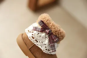 Detailed view of girls' winter plush boots featuring lace collar and plaid bow decoration