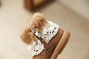 Detail view of girls' brown boots with white lace trim and cozy faux fur lining