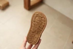 Close-up detail of brown anti-slip rubber sole with texture for children's winter boots.