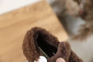 Detailed view of the thick soft fleece lining inside kids' brown fuzzy winter shoes.