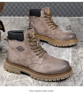 Vintage brown leather men's work boots with wear-resistant rubber outsole on wood.