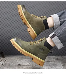 Close-up of olive green suede work boots showing durable yellow rubber outsoles