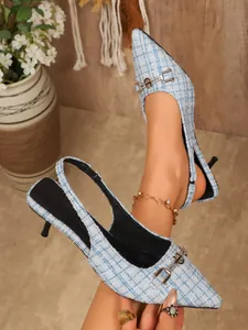 Close-up of light blue tweed slingback pumps with rhinestone buckles and pointed toes.