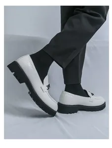 Détail de mocassins blancs pour hommes avec cuir texturé et semelle noire épaisse.