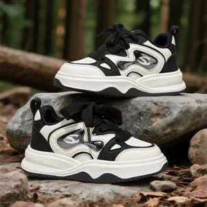 Zapatillas deportivas blancas y negras para niñas en rocas naturales del bosque