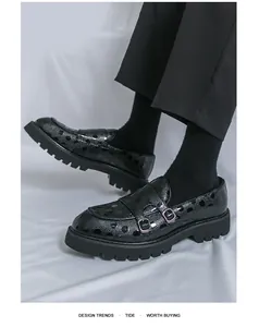 Détail de mocassins monk noirs à pois découpés au laser et semelles crantées