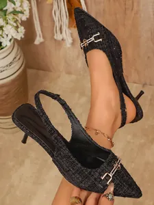 Close-up view of elegant black tweed slingback kitten heels with a metal buckle