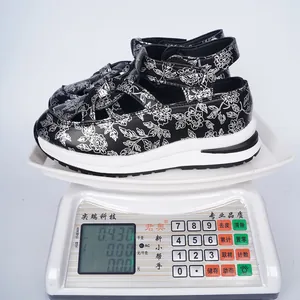 Detailed shot of floral platform sandals weighing 0.43kg on an electronic scale