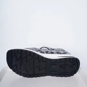 Detail view of the floral pattern and anti-slip rubber outsole of wedge sandals