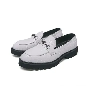 Mocassins blancs texturés pour hommes avec semelles noires épaisses et mors en métal.