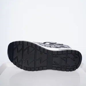 Detailed macro view of the non-slip rubber sole on black wedge platform sandals