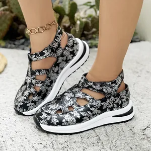 Detail view of stylish black floral wedge sandals with comfortable velcro straps