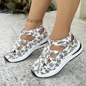 Floral print wedge sandals with thick platform soles and velcro straps shown on feet outdoors