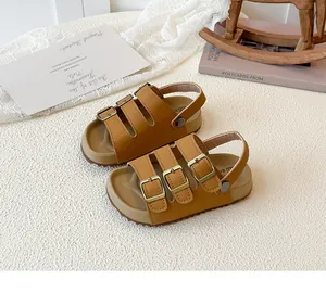 Close-up view of brown toddler sandals with adjustable triple buckle straps and cork soles.