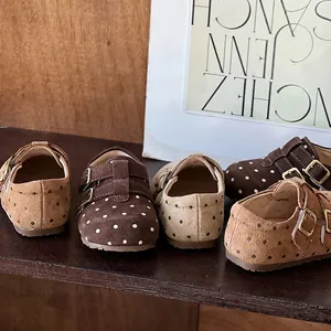 Detailed view of girls' polka dot suede loafers featuring elegant double buckle straps