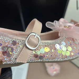Close-up of pink sparkly girls' princess shoes with bow and iridescent sequins
