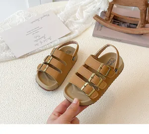 Close-up of children's tan triple-buckle sandals with cork soles for summer wear.