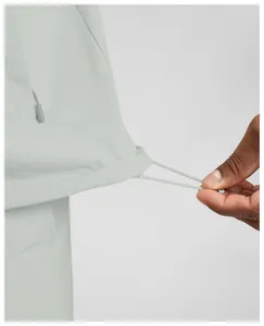 Close-up view of adjustable drawstring hem on light grey men's quick-dry athletic jacket