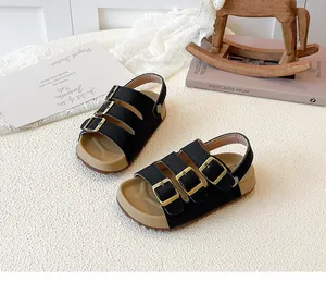 Detailed view of black children's cork sandals with three adjustable gold buckles