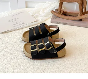 Detail view of kids' black sandals with cork soles and adjustable buckle straps