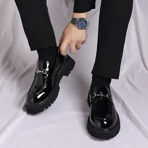 Nahaufnahme glänzend schwarzer Plateau-Loafer für Herren mit silberner Metallschnalle