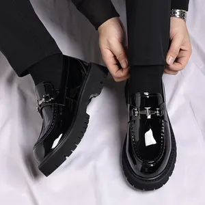 Detailaufnahme von schwarzen Lackleder-Loafern mit dicken Sohlen und Metallschnalle