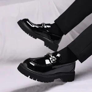 Nahaufnahme von glänzenden schwarzen Lack-Loafers mit silberner Schnalle und Plateausohle
