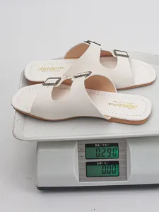Detailansicht der weißen Damen-Schnallensandalen auf einer Waage mit 0,290 kg Gewicht.
