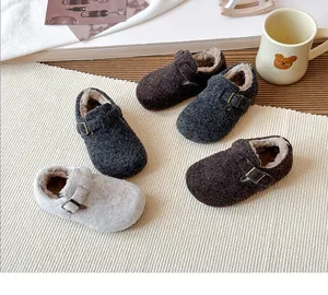 Close-up of children's cozy winter clogs with plush faux fur lining and buckles
