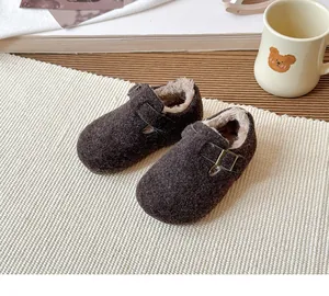 Cozy brown children's Birkenstock shoes with plush fur lining and retro metal buckle detail