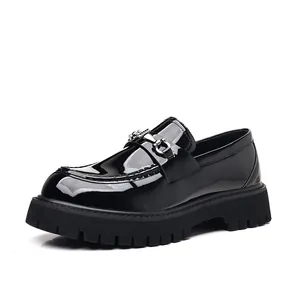 Close-up of black patent leather loafers with chunky lug soles and metal buckle.
