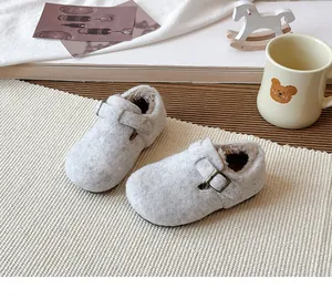Close-up of cozy kids' felt clogs with warm fur lining and adjustable metal buckle strap.