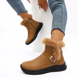 Gros plan de bottes de neige marron pour femmes avec bordure en fausse fourrure et boucle
