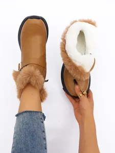 Détails de bottes de neige marron avec doublure en fausse fourrure et zip.