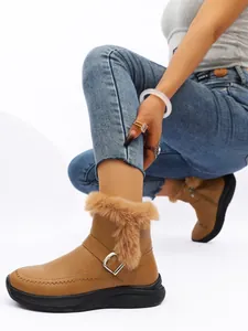 Vue détaillée de bottes de neige marron pour femmes avec fausse fourrure et boucle élégante.