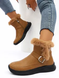 Gros plan détaillé des bottes de neige marron pour femmes avec fourrure et boucle