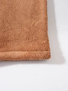 Close-up detail of soft brown coral fleece fabric texture on jacket
